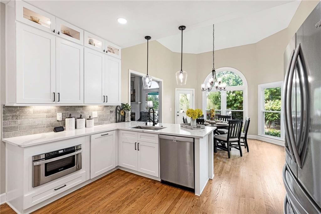 802 Clubhouse Pointe Woodstock, GA 30188 - Photo 10 of 66 a open kitchen with stainless steel appliances granite countertop a stove a sink dishwasher a refrigerator with wooden floor
