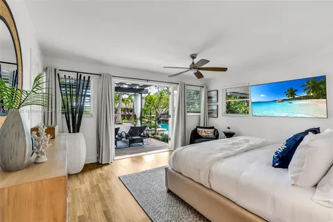 a bedroom with a large bed and a large window with wooden floor