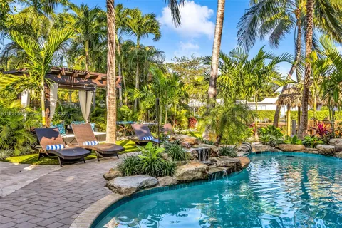 a row of tall buildings with lawn chairs under an umbrella