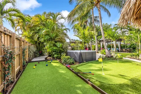 a view of a patio with table and chairs potted plants and large tree