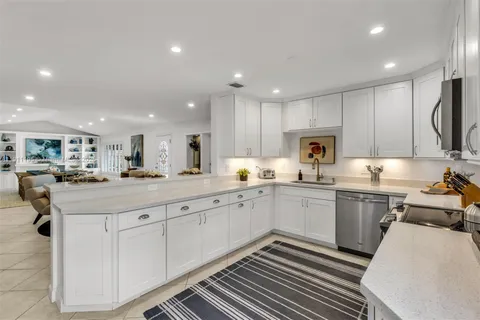 a kitchen with sink cabinets and chairs