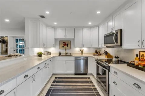 a kitchen with a sink a stove and cabinets