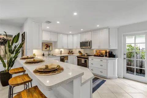 a kitchen with white cabinets and appliances