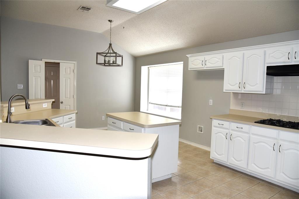 1526 Pebblestone Court Allen, TX 75002 - Photo 6 of 28 Kitchen featuring white cabinetry, light-toned countertops, a built-in gas range, a white subway tile backsplash, and ceramic tile flooring