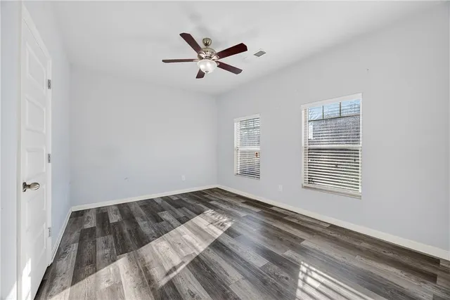 a view of a room with window ceiling fan and hardwood floor