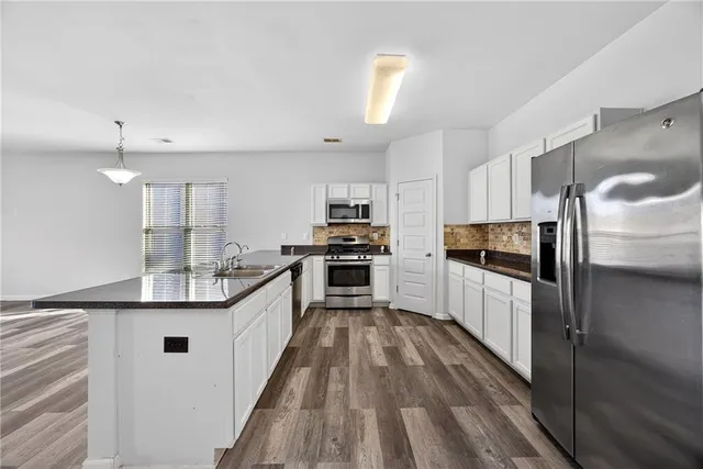 a kitchen with kitchen island granite countertop lots of counter top space and stainless steel appliances