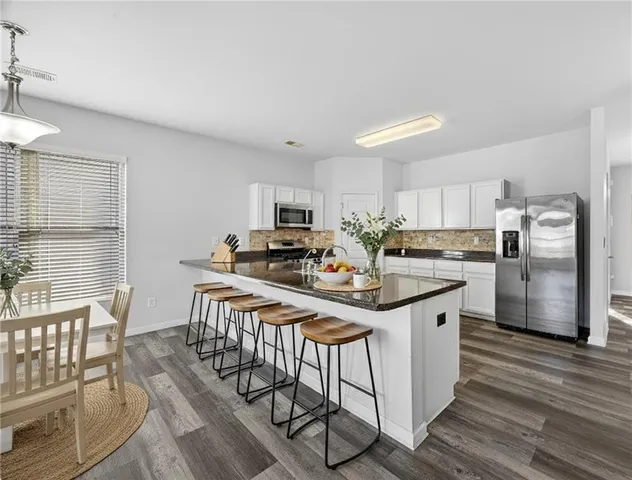 a kitchen with stainless steel appliances kitchen island granite countertop a sink and cabinets
