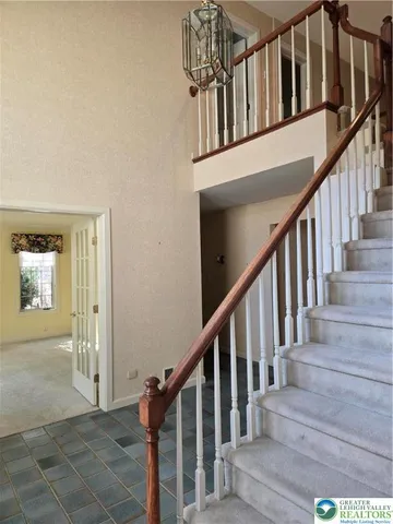 a view of staircase with lots of frames on wall and wooden floor