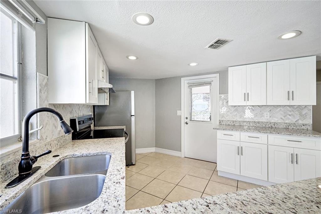 321 Dania Street Lehigh Acres, FL 33936 - Photo 12 of 22 a kitchen with a sink cabinets and window