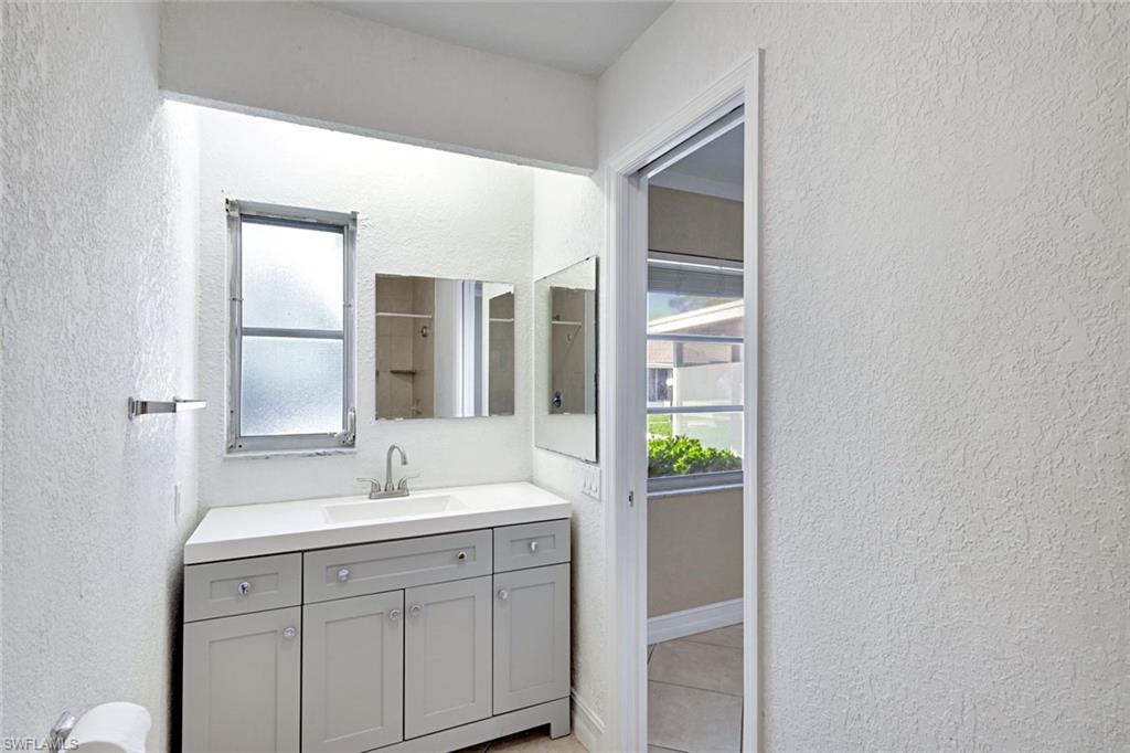 321 Dania Street Lehigh Acres, FL 33936 - Photo 13 of 22 a bathroom with a sink and a mirror