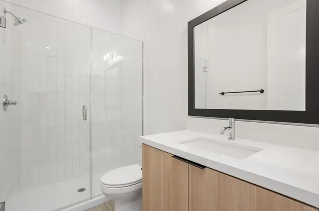 a bathroom with a sink a toilet and shower