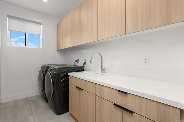 a utility room with sink dryer and washer