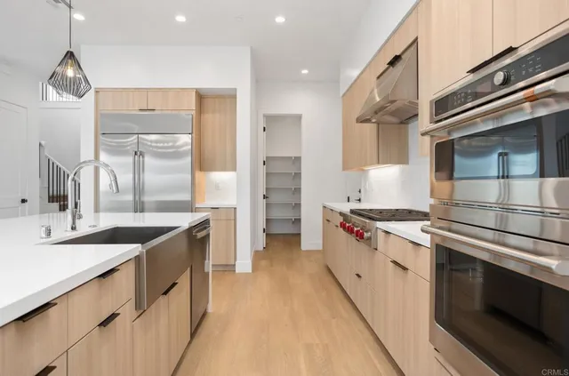 a kitchen with stainless steel appliances granite countertop a sink and a stove top oven