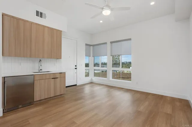 a kitchen with wooden floors and white cabinets