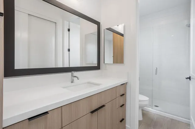 a bathroom with a sink a toilet and a large mirror