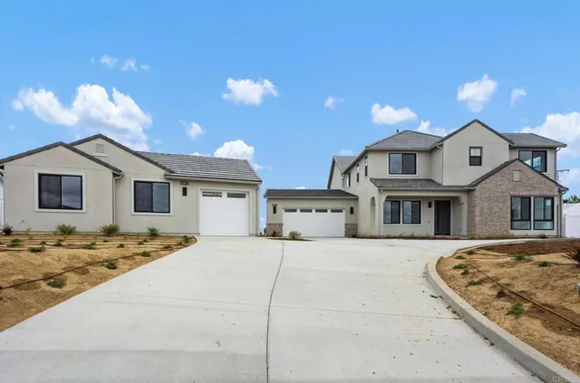 a view of a house with snow on the side of road