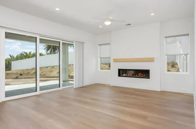 an empty room with floor to ceiling window and fireplace
