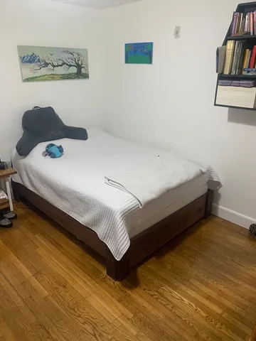 a bedroom with a bed and book shelf