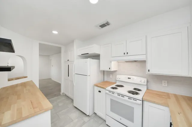 a kitchen with a stove a refrigerator and a sink
