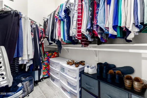 a view of walk in closet with clothes and shoes