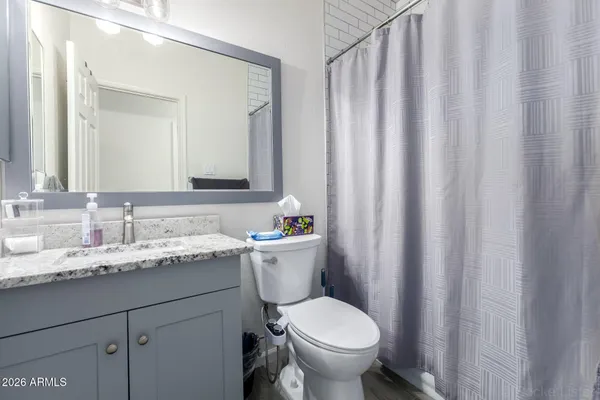 a bathroom with a granite countertop sink and a toilet