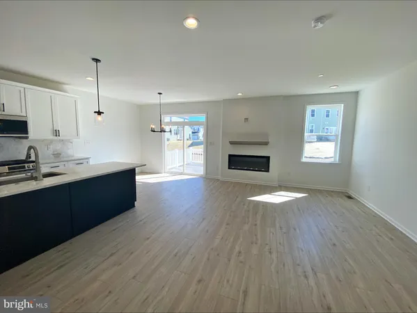 a kitchen with granite countertop a stove top oven a sink and dishwasher with wooden floor