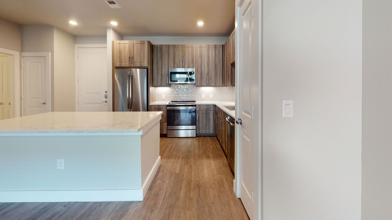 24002 Colonial Parkway, Unit 6130 Katy, TX 77493 - Photo 3 of 31 a large kitchen with a large counter top a refrigerator and wooden cabinets
