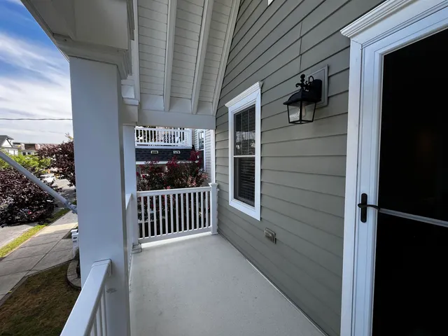 a living room with a flat screen tv on dresser and a wooden floor