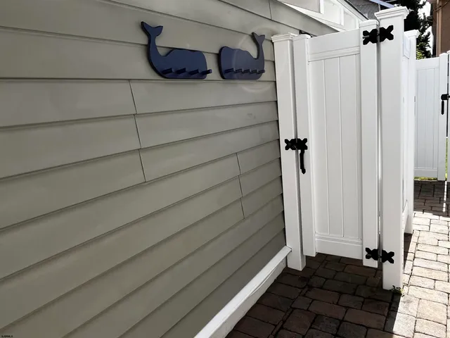 a small white building with a clock on the door