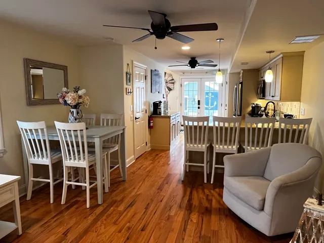 a dining room with furniture a chandelier and wooden floor