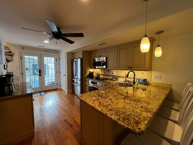 a kitchen with granite countertop stainless steel appliances a sink cabinets and a counter top space
