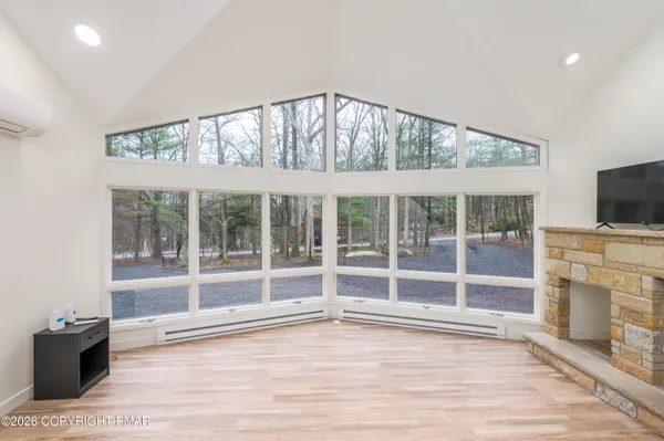an empty room with wooden floor and fireplace