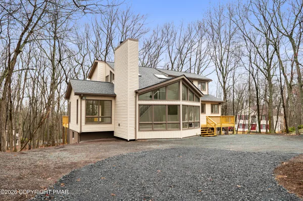 a view of a house with a large tree and a yard