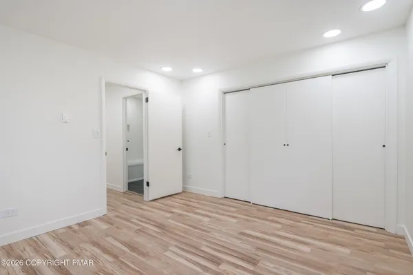 a view of a room with wooden floor and a bathroom