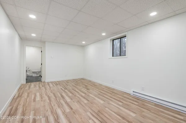 an empty room with wooden floor and bathroom