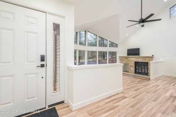 a view of a livingroom with wooden floor and a kitchen space