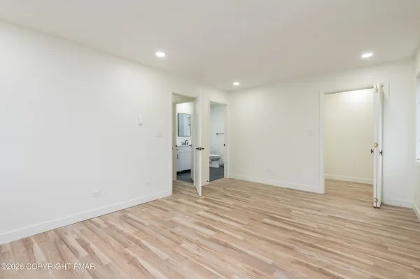 a view of empty room with wooden floor