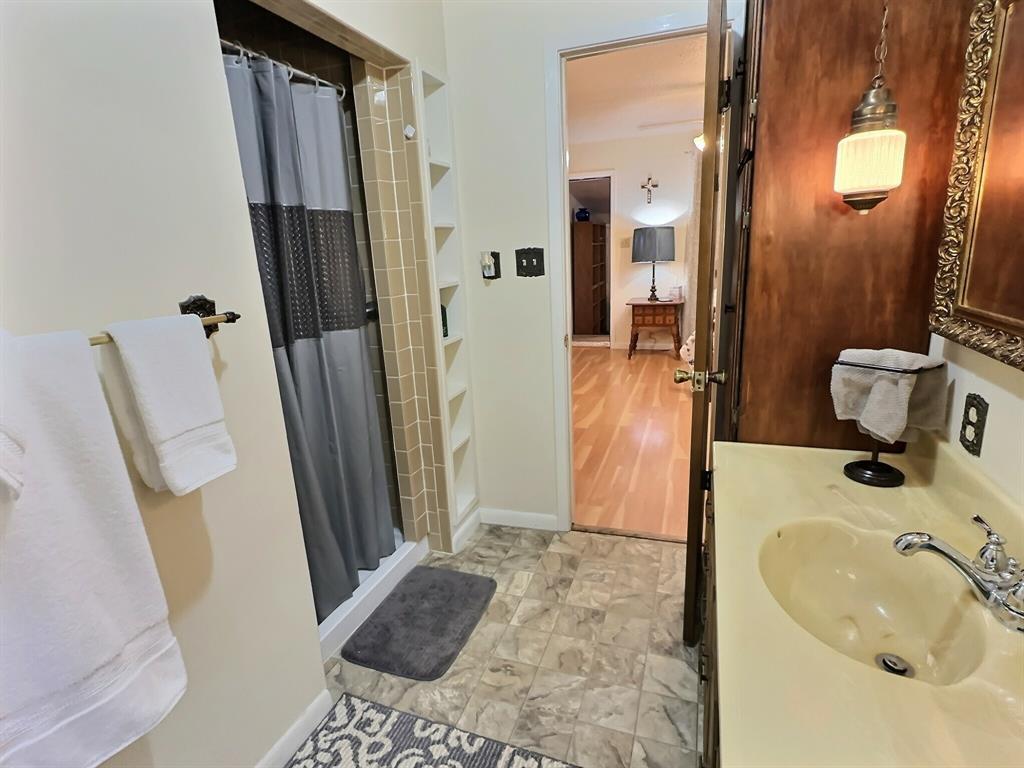 300 South Miller Street Rising Star, TX 76471 - Photo 18 of 39 a bathroom with a sink a toilet a mirror and tub