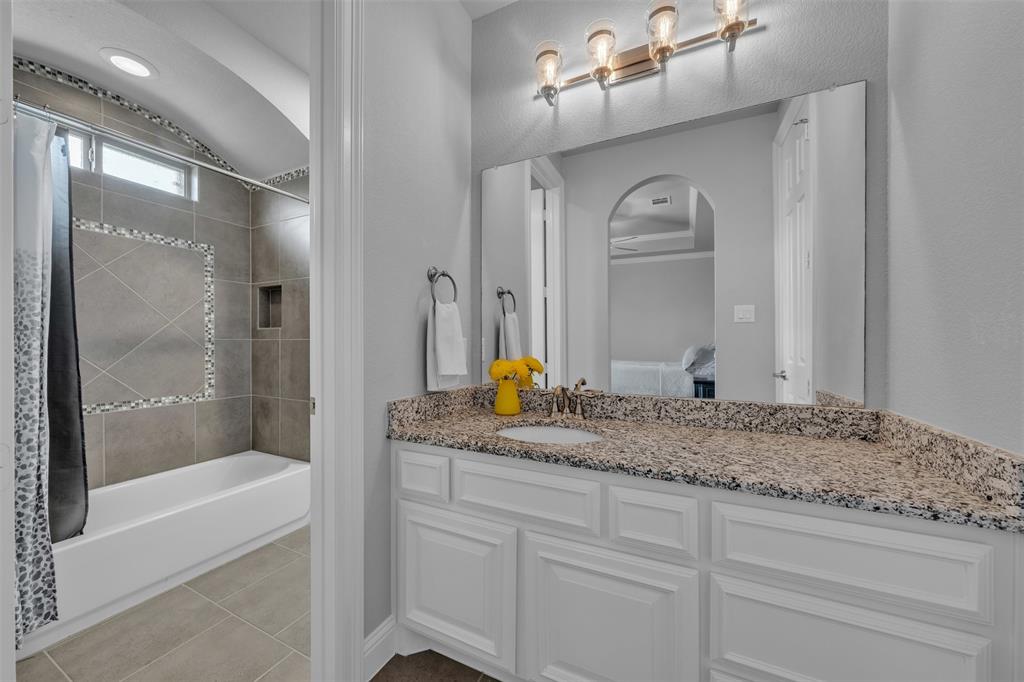 1060 Waters Edge Court Oak Point, TX 75068 - Photo 13 of 40 a bathroom with a granite countertop sink a mirror and a bathtub