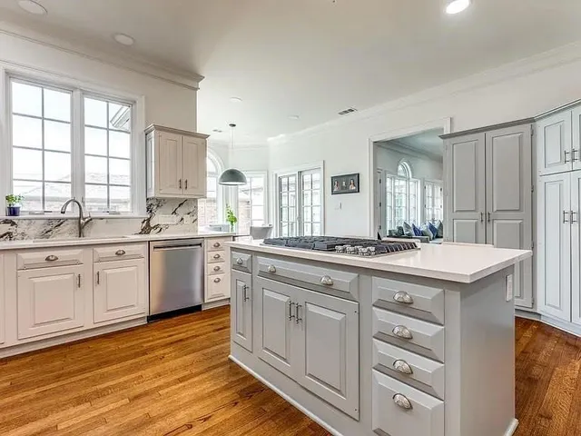 a kitchen with a sink stove cabinets and wooden floor