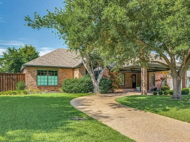 a front view of a house with a yard and trees