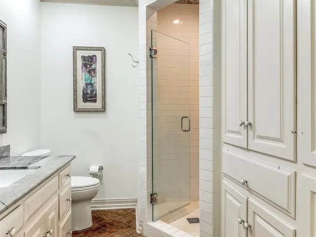 a bathroom with a granite countertop toilet a sink and a mirror