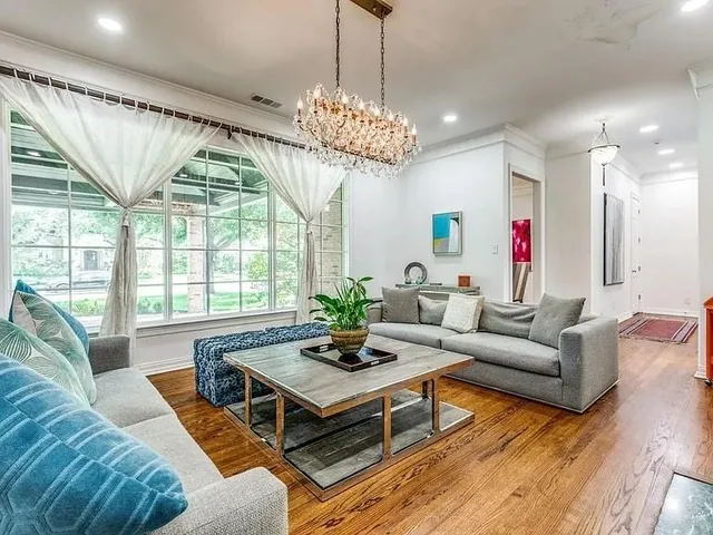 a living room with furniture chandelier and a large window