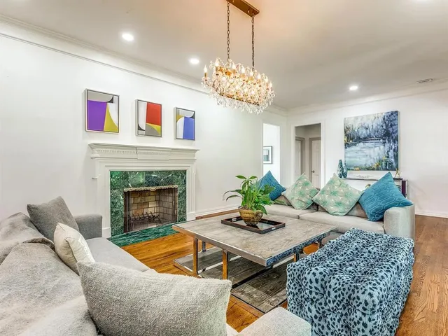 a living room with furniture a chandelier and a fireplace