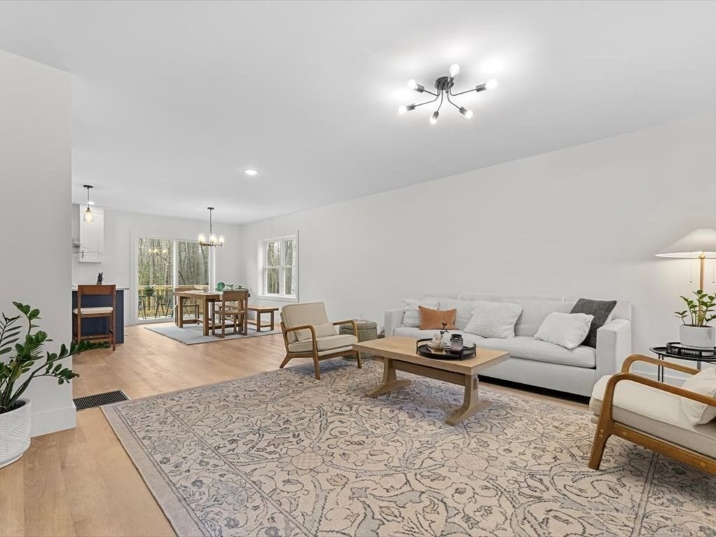 560 Queen Lake Road Phillipston, MA 01331 - Photo 7 of 42 a living room with furniture and a chandelier
