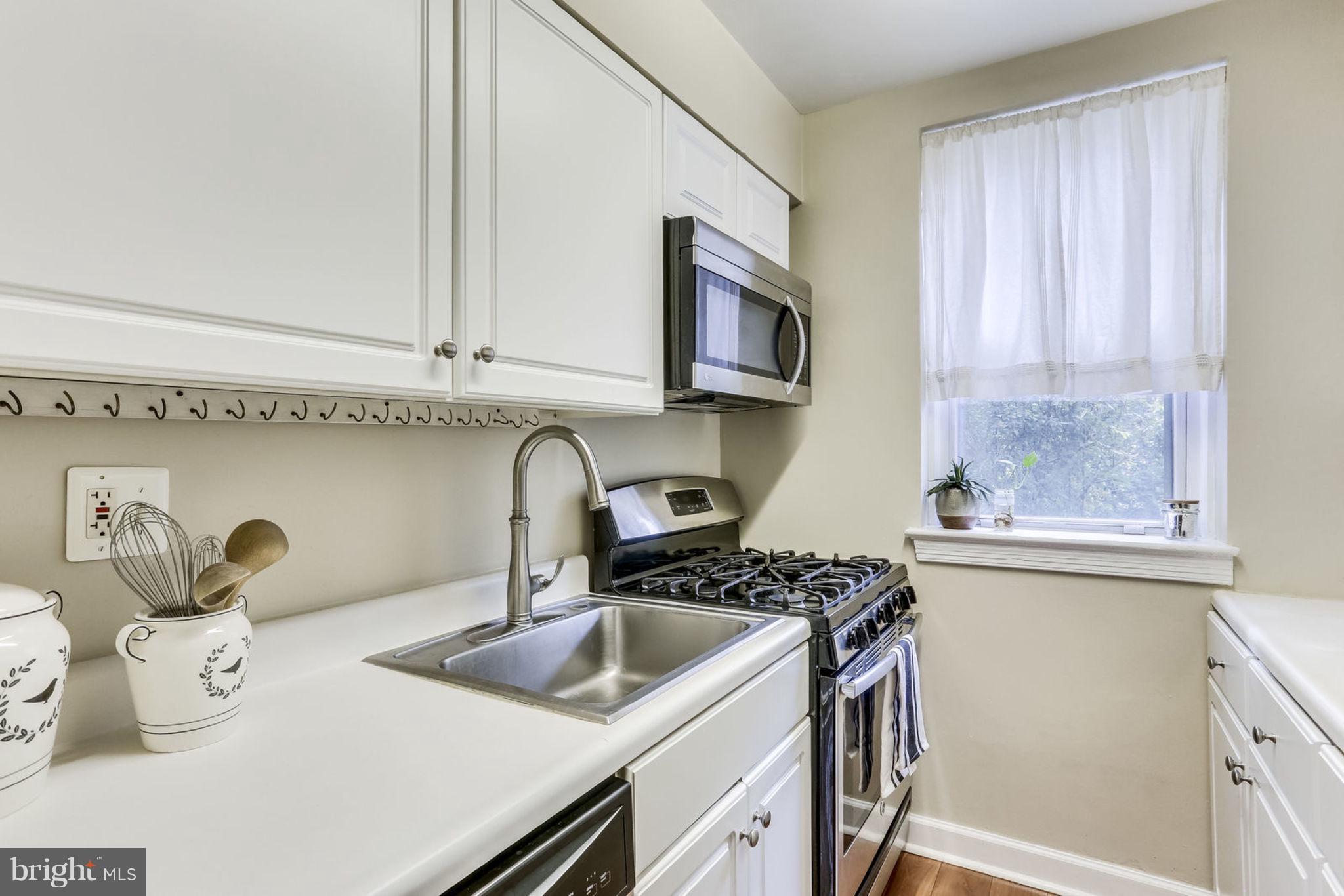 24 South Old Glebe Road, Unit 2C Arlington, VA 22204 - Photo 8 of 24 a kitchen with stainless steel appliances granite countertop a sink a stove and a microwave