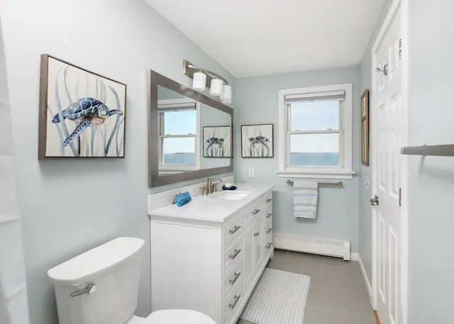 a bathroom with a sink a toilet and a window