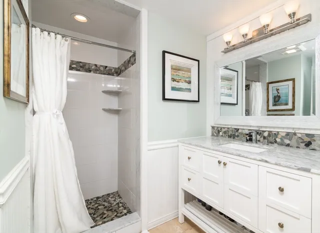 a bathroom with a sink a mirror and a shower