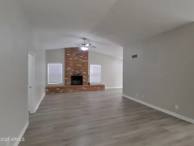 an empty room with wooden floor and fireplace