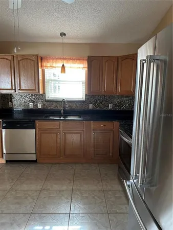 a kitchen with granite countertop a stove top oven sink and cabinets